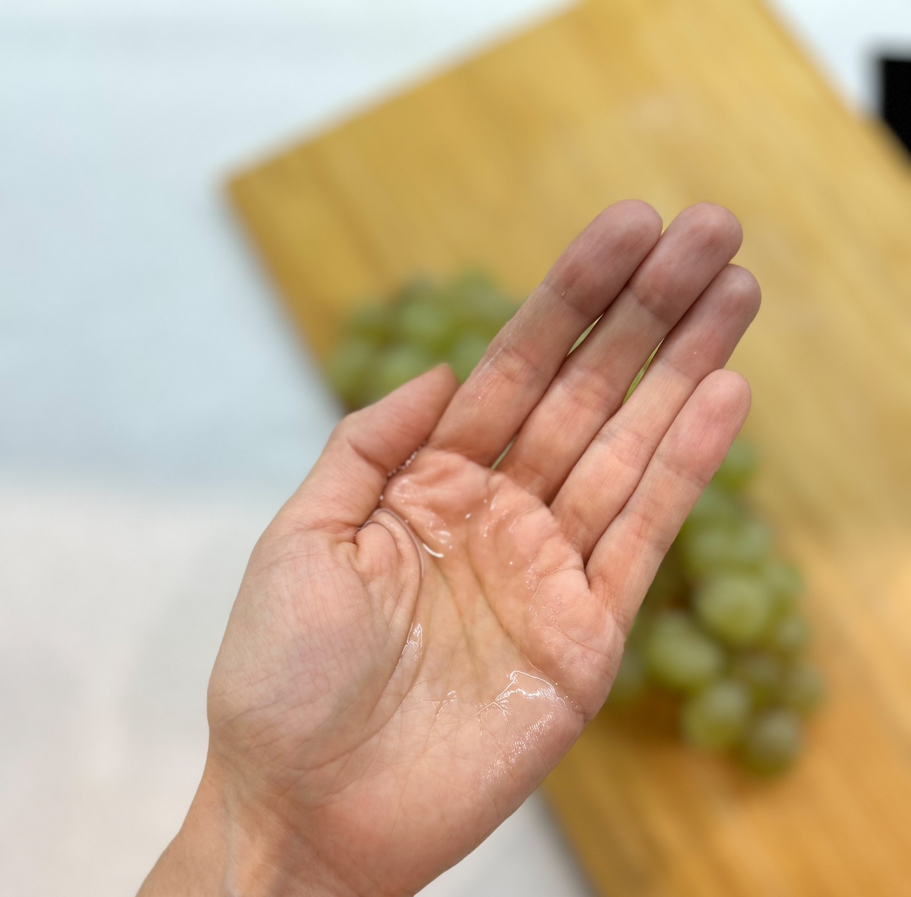 Drops of grapeseed oil on a palm, close-up.