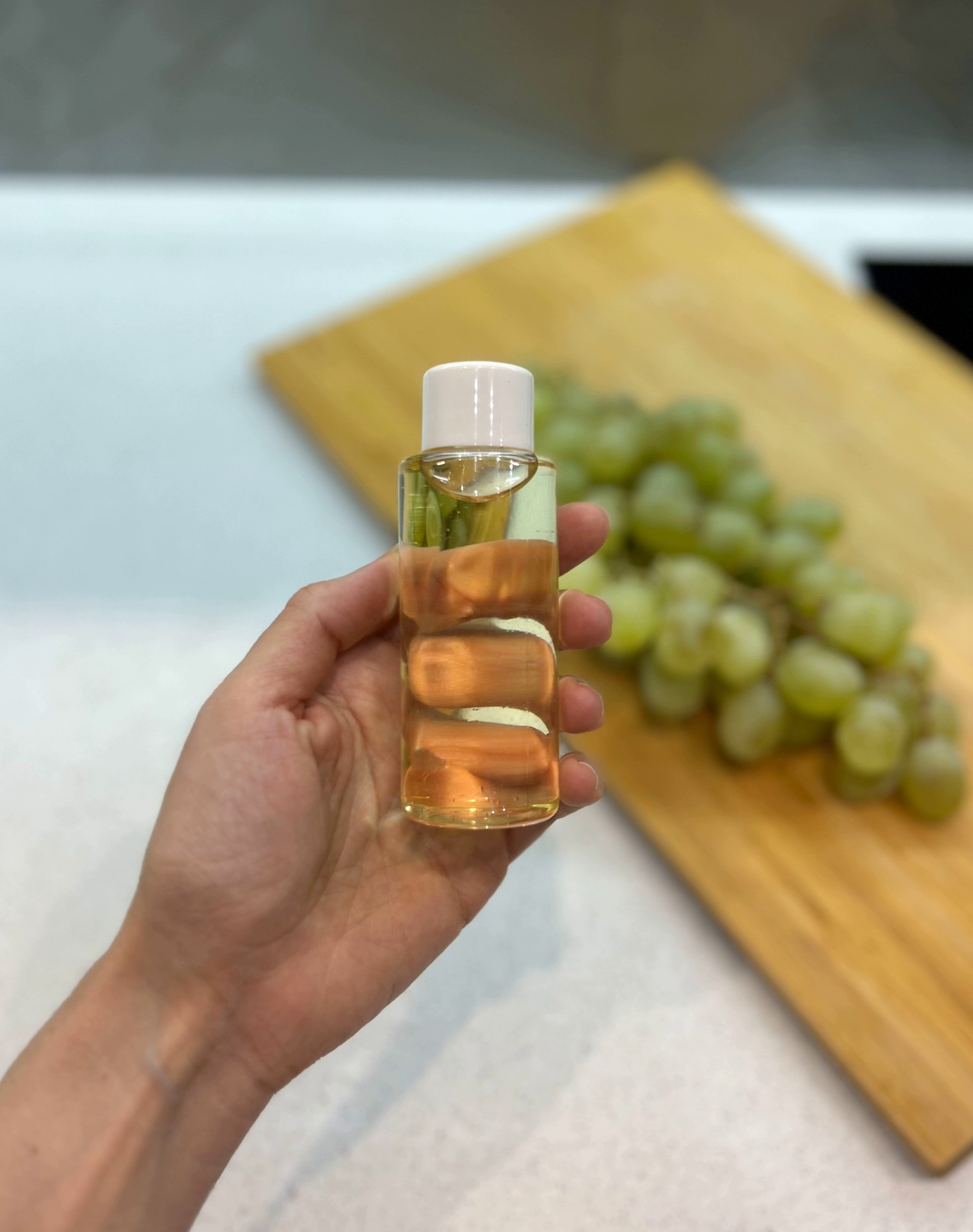 Bottle of grapeseed oil held in hand